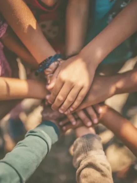 Diverse youth hands joined together — community and teamwork