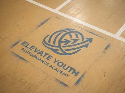Elevate Youth logo on gymnasium court floor — concept mockup